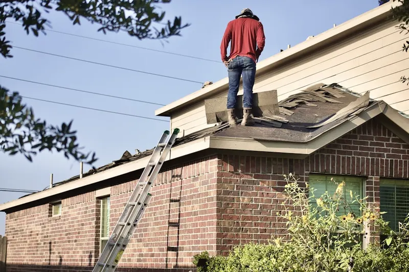 Professional roofer working on a residential roof in Mansfield Four Corners